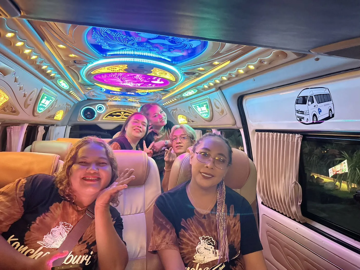 Guests relaxing in the van under its neon-lit ceiling